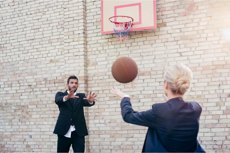 mand-i-jakkesaet-spiller-basket-med-kvinde
